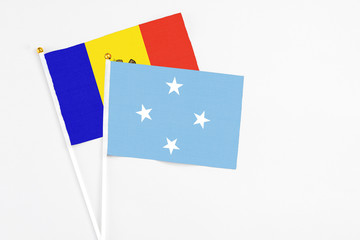 Micronesia and Moldova stick flags on white background. High quality fabric, miniature national flag. Peaceful global concept.White floor for copy space.