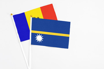 Nauru and Moldova stick flags on white background. High quality fabric, miniature national flag. Peaceful global concept.White floor for copy space.