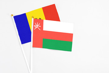 Oman and Moldova stick flags on white background. High quality fabric, miniature national flag. Peaceful global concept.White floor for copy space.