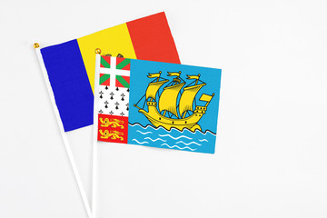 Saint Pierre And Miquelon and Moldova stick flags on white background. High quality fabric, miniature national flag. Peaceful global concept.White floor for copy space.