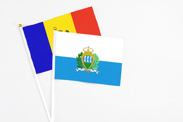 San Marino and Moldova stick flags on white background. High quality fabric, miniature national flag. Peaceful global concept.White floor for copy space.