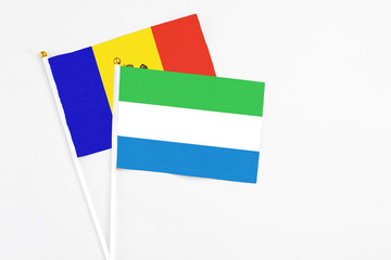 Sierra Leone and Moldova stick flags on white background. High quality fabric, miniature national flag. Peaceful global concept.White floor for copy space.