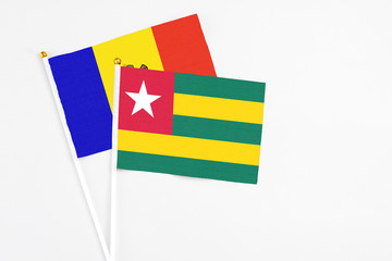 Togo and Moldova stick flags on white background. High quality fabric, miniature national flag. Peaceful global concept.White floor for copy space.