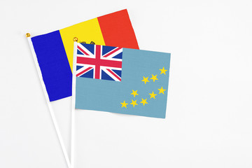 Fototapeta premium Tuvalu and Moldova stick flags on white background. High quality fabric, miniature national flag. Peaceful global concept.White floor for copy space.