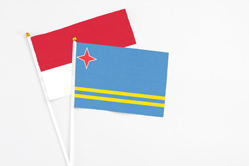 Aruba and Monaco stick flags on white background. High quality fabric, miniature national flag. Peaceful global concept.White floor for copy space.