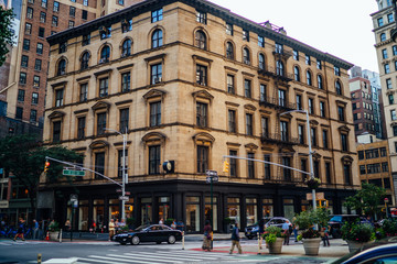 Urban setting of downtown with traffic on roads and high vintage building with apartment and flats...