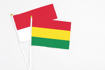 Bolivia and Monaco stick flags on white background. High quality fabric, miniature national flag. Peaceful global concept.White floor for copy space.