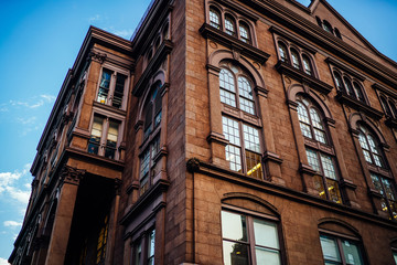 Historic building with big vintage windows on exterior with apartments for residents in district of megalopolis,angle view of beautiful old architecture facade with real estate for rent inside .