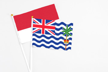 Fototapeta premium British Indian Ocean Territory and Monaco stick flags on white background. High quality fabric, miniature national flag. Peaceful global concept.White floor for copy space.