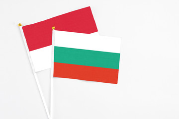 Bulgaria and Monaco stick flags on white background. High quality fabric, miniature national flag. Peaceful global concept.White floor for copy space.