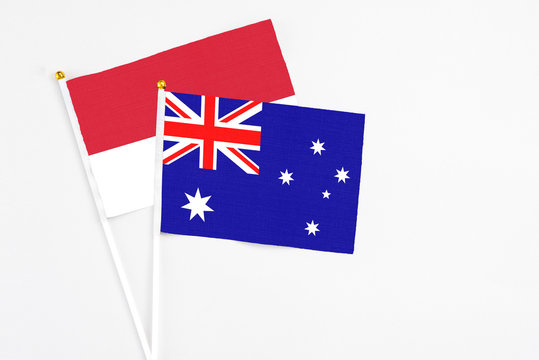 Australia and Monaco stick flags on white background. High quality fabric, miniature national flag. Peaceful global concept.White floor for copy space.