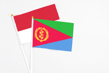 Eritrea and Monaco stick flags on white background. High quality fabric, miniature national flag. Peaceful global concept.White floor for copy space.