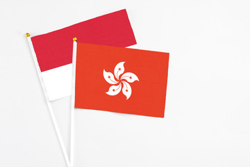 Hong Kong and Monaco stick flags on white background. High quality fabric, miniature national flag. Peaceful global concept.White floor for copy space.