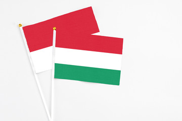 Hungary and Monaco stick flags on white background. High quality fabric, miniature national flag. Peaceful global concept.White floor for copy space.