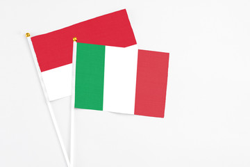 Italy and Monaco stick flags on white background. High quality fabric, miniature national flag. Peaceful global concept.White floor for copy space.