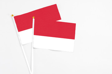 Monaco and Monaco stick flags on white background. High quality fabric, miniature national flag. Peaceful global concept.White floor for copy space.