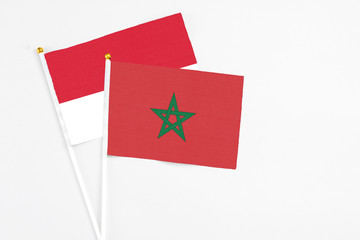 Morocco and Monaco stick flags on white background. High quality fabric, miniature national flag. Peaceful global concept.White floor for copy space.