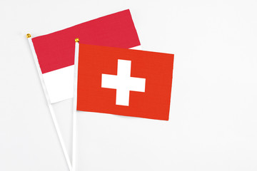 Switzerland and Monaco stick flags on white background. High quality fabric, miniature national flag. Peaceful global concept.White floor for copy space.