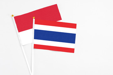 Thailand and Monaco stick flags on white background. High quality fabric, miniature national flag. Peaceful global concept.White floor for copy space.