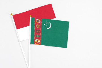 Turkmenistan and Monaco stick flags on white background. High quality fabric, miniature national flag. Peaceful global concept.White floor for copy space.