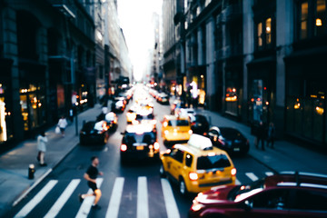 Fototapeta na wymiar Blurred photo of big city life with traffic on road and pedestrian passing crosswalk in downtown, cityscape with modern architecture and transport moving on avenue in district of New York megalopolis