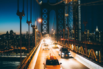 Circulation métropolitaine sur le pont de Brooklyn avec des véhicules brillants de la lumière du soir, taxis jaunes conduisant de Manhattan à un autre quartier, traversées de rivières, concept de réduction de l& 39 impact environnemental