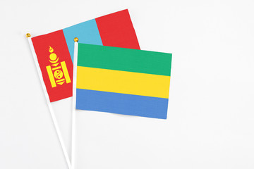 Gabon and Mongolia stick flags on white background. High quality fabric, miniature national flag. Peaceful global concept.White floor for copy space.