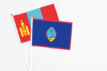 Guam and Mongolia stick flags on white background. High quality fabric, miniature national flag. Peaceful global concept.White floor for copy space.