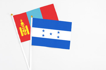 Honduras and Mongolia stick flags on white background. High quality fabric, miniature national flag. Peaceful global concept.White floor for copy space.