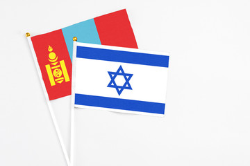 Israel and Mongolia stick flags on white background. High quality fabric, miniature national flag. Peaceful global concept.White floor for copy space.