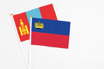 Liechtenstein and Mongolia stick flags on white background. High quality fabric, miniature national flag. Peaceful global concept.White floor for copy space.