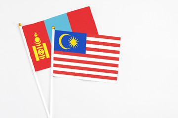 Malaysia and Mongolia stick flags on white background. High quality fabric, miniature national flag. Peaceful global concept.White floor for copy space.