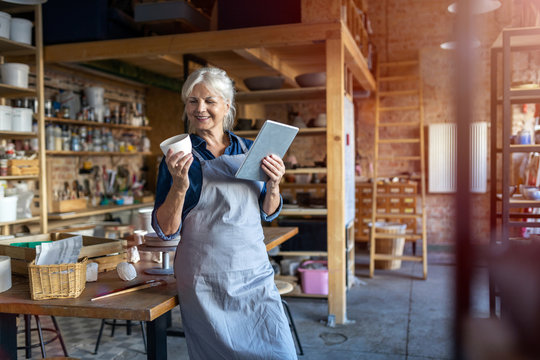 Senior craftswoman with tablet computer in art studio