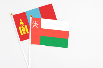 Oman and Mongolia stick flags on white background. High quality fabric, miniature national flag. Peaceful global concept.White floor for copy space.