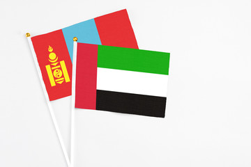 United Arab Emirates and Mongolia stick flags on white background. High quality fabric, miniature national flag. Peaceful global concept.White floor for copy space.