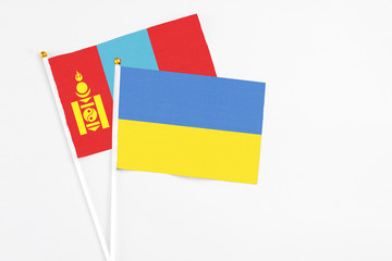Ukraine and Mongolia stick flags on white background. High quality fabric, miniature national flag. Peaceful global concept.White floor for copy space.