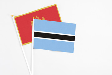 Botswana and Montenegro stick flags on white background. High quality fabric, miniature national flag. Peaceful global concept.White floor for copy space.