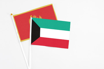 Kuwait and Montenegro stick flags on white background. High quality fabric, miniature national flag. Peaceful global concept.White floor for copy space.