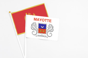Mayotte and Montenegro stick flags on white background. High quality fabric, miniature national flag. Peaceful global concept.White floor for copy space.