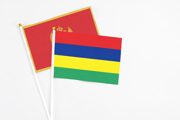 Mauritius and Montenegro stick flags on white background. High quality fabric, miniature national flag. Peaceful global concept.White floor for copy space.