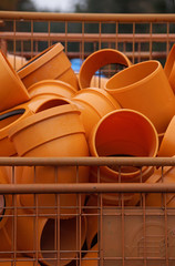 Container mit Winkelstücken von Plastik-Abwasserrohren auf einer Baustelle für ein Neubaugebiet