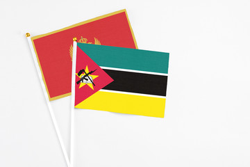 Mozambique and Montenegro stick flags on white background. High quality fabric, miniature national flag. Peaceful global concept.White floor for copy space.