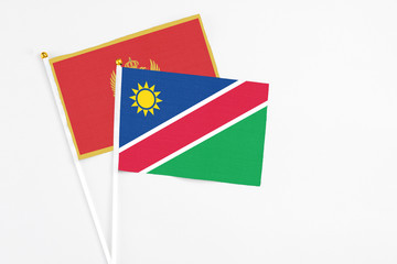 Namibia and Montenegro stick flags on white background. High quality fabric, miniature national flag. Peaceful global concept.White floor for copy space.