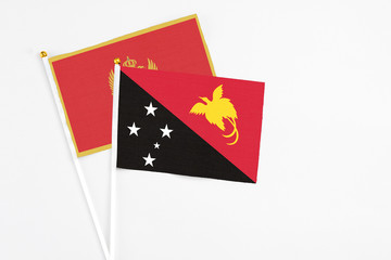 Papua New Guinea and Montenegro stick flags on white background. High quality fabric, miniature national flag. Peaceful global concept.White floor for copy space.