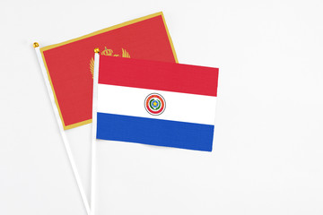 Paraguay and Montenegro stick flags on white background. High quality fabric, miniature national flag. Peaceful global concept.White floor for copy space.