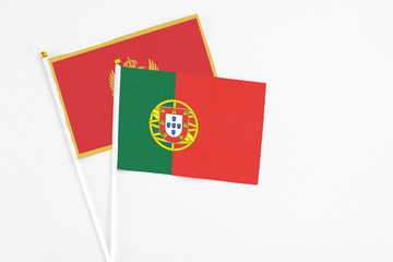 Portugal and Montenegro stick flags on white background. High quality fabric, miniature national flag. Peaceful global concept.White floor for copy space.