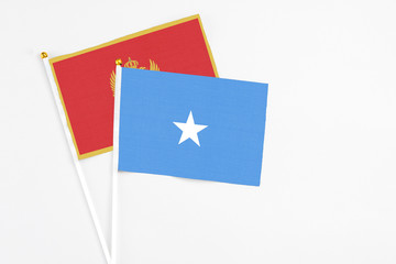 Somalia and Montenegro stick flags on white background. High quality fabric, miniature national flag. Peaceful global concept.White floor for copy space.