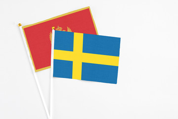 Sweden and Montenegro stick flags on white background. High quality fabric, miniature national flag. Peaceful global concept.White floor for copy space.