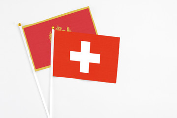Switzerland and Montenegro stick flags on white background. High quality fabric, miniature national flag. Peaceful global concept.White floor for copy space.