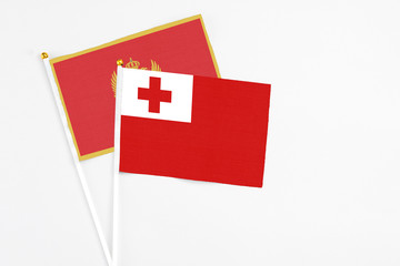 Tonga and Montenegro stick flags on white background. High quality fabric, miniature national flag. Peaceful global concept.White floor for copy space.
